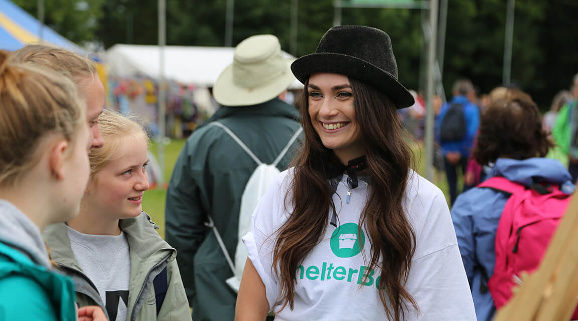 A lady chatting to young people about Shelterbox