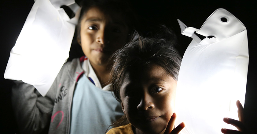 Two children holding solar lights