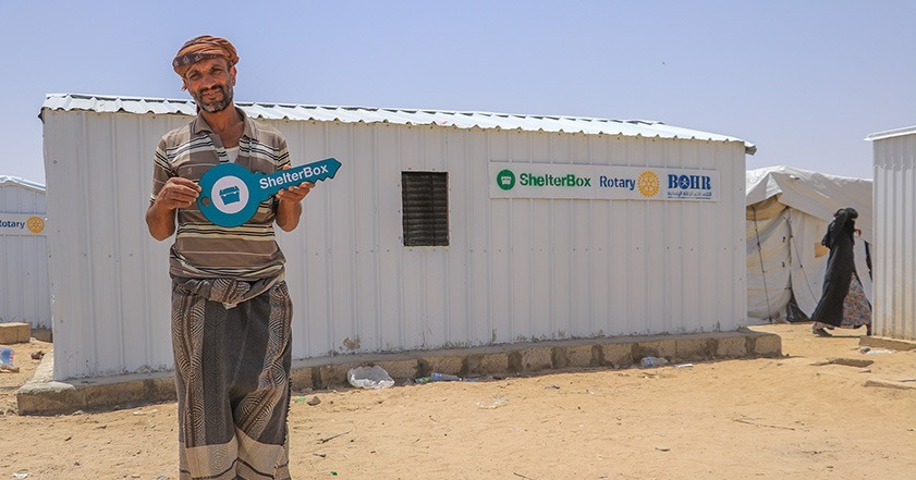 Man standing outside iron net shelter