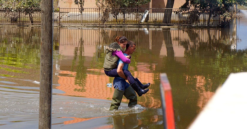 Man carries woman through floodwater in Serbia