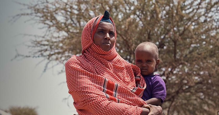 Woman in red headscarf holding a child in Somaliland