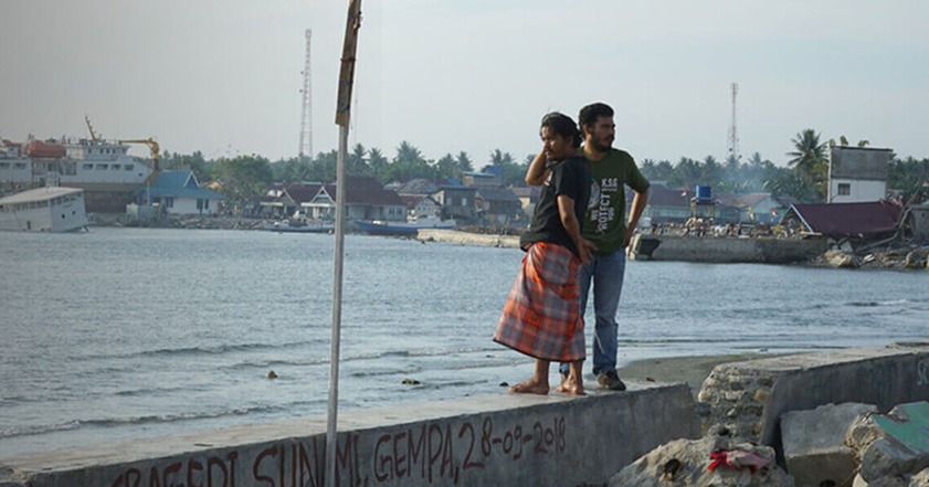 People standing on coast in Indonesia after a tsunami